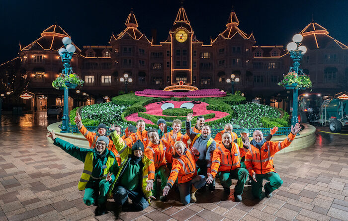 Cast Members in the middle of the night at Disneyland Paris in front of the Minnie Mouse planter
