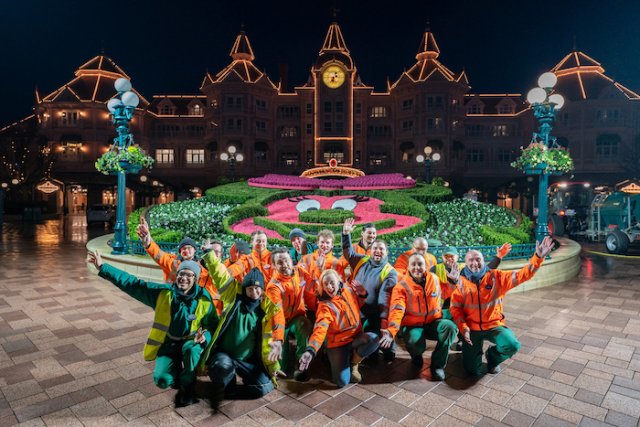 Cast Members in the middle of the night at Disneyland Paris in front of the Minnie Mouse planter