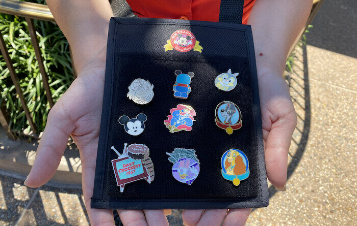 Disney Pins being traded by a Cast Member